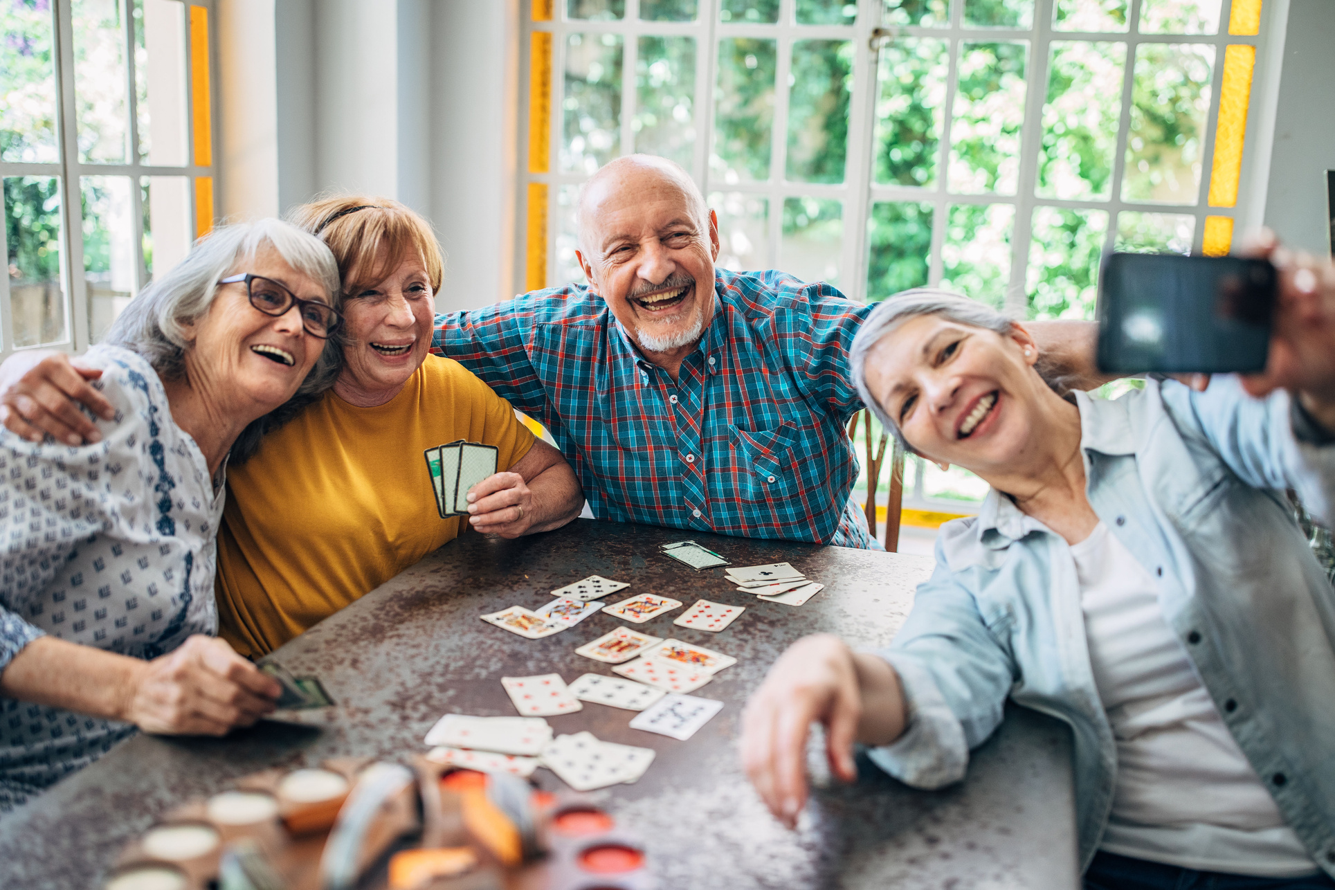 Selfie of old people playing cards in nursing home